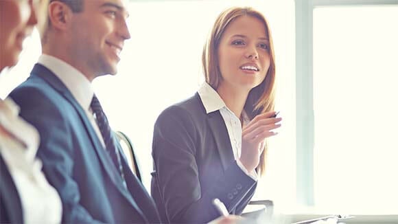 woman asking a question in a business meeting woman asking a question in a business meeting sitting next to colleagues