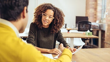 Woman in glasses speaking to her employer about entering a mentor programme at work