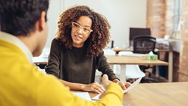 Woman speaking to her employer mentoring Woman in glasses speaking to her employer about entering a mentor programme at work
