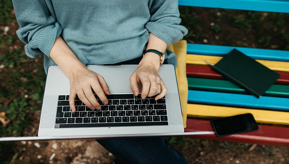 Lady on a laptop on the bench