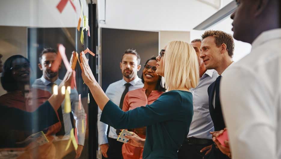Young businesswoman and her team brainstorming with sticky notes